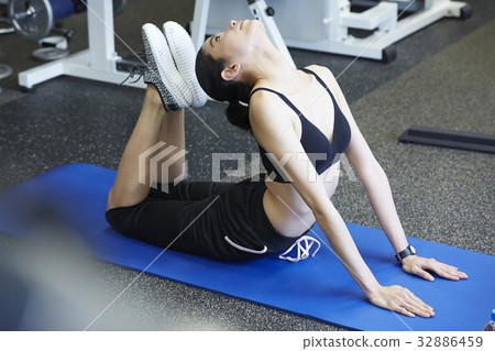 A girl is practising a stretching exercise at a sport club A girl is practising a stretching exercise at a sport club 32886459