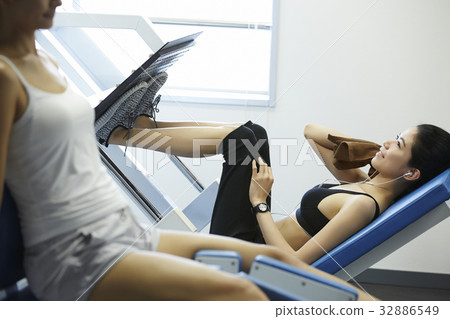 two women are exercising in gym club two women are exercising in gym club 32886549