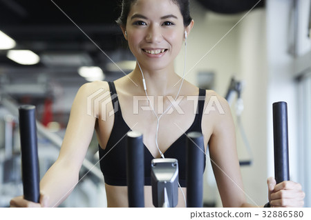 Woman is smiling happily while practising in fitness club Woman is smiling happily while practising in fitness club 32886580