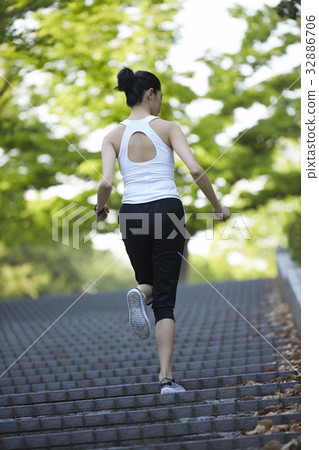The girl is running up on steps of the stair The girl is running up on steps of the stair 32886706