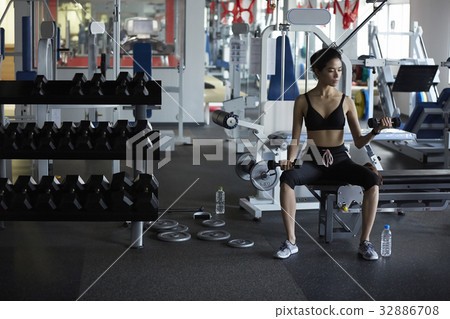 The girl is doing weight lifting in the sport club The girl is doing weight lifting in the sport club 32886708