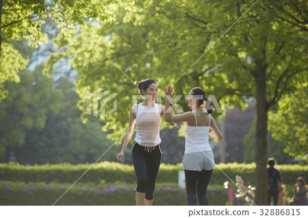 a photo of two women making high five when running in the morning. a photo of two women making high five when running in the morning. 32886815