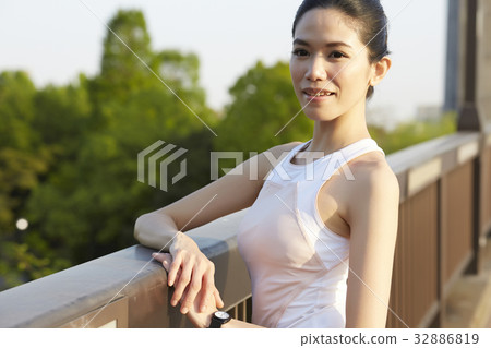 a photo of a woman in sportswear smiling and looking at something. 32886819