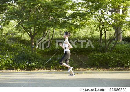 a photo of a woman running in a park. a photo of a woman running in a park. 32886831
