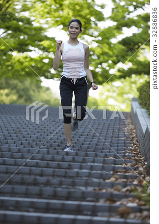 a photo of a woman in sportswear running on steps. 32886836