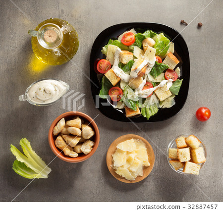 caesar salad and ingredients at table 32887457
