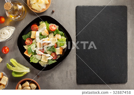 caesar salad and ingredients at table 32887458