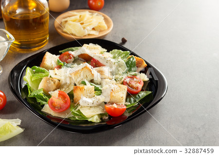 caesar salad and ingredients at table 32887459