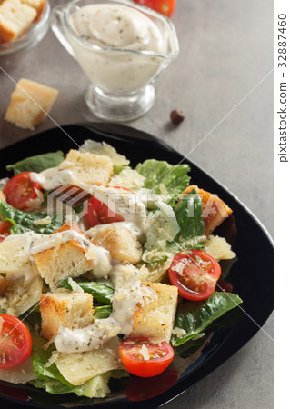 caesar salad and ingredients at table 32887460