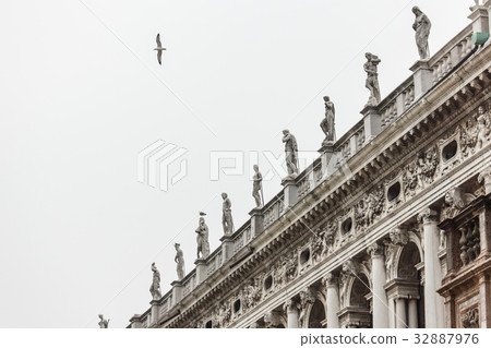 Seagull fly above sculpture at Venice library. 32887976