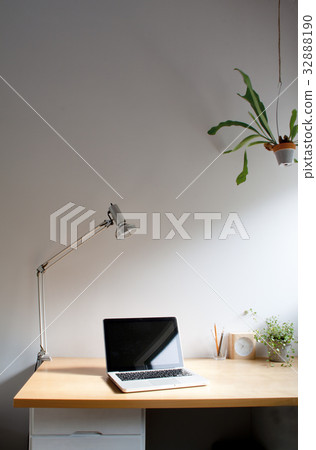 在書桌上的膝上型計算機工作區有種植的樹的在陽光下 在書桌上的膝上型計算機工作區有種植的樹的在陽光下 32888190