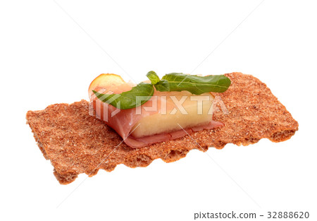 Parma ham with melon and basil on a rye crisp 32888620