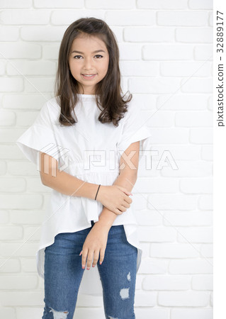 Happy cute girl with blue jeans and smiling looking at camera. Happy cute girl with blue jeans and smiling looking at camera. 32889177