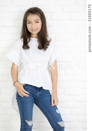 Happy cute girl with blue jeans and smiling looking at camera. Happy cute girl with blue jeans and smiling looking at camera. 32889178