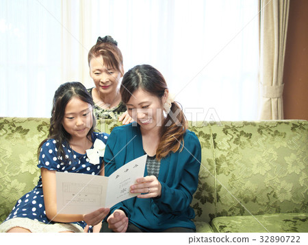 A mother and a grandmother who look at a girl child and "Ayumi" (a report book). (A school badge, a school dummy does not exist fictional dummy) 32890722