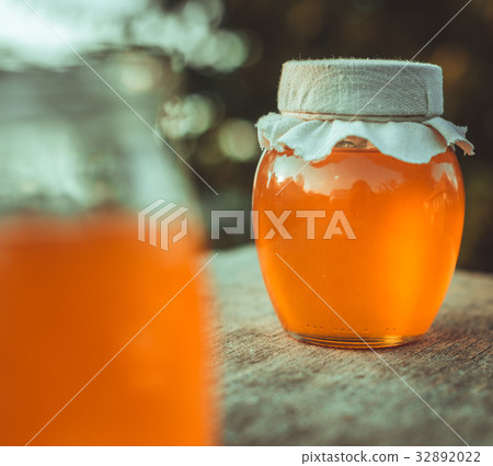 Two cans of natural honey. Honey on the fabric. 32892022