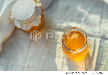 Two cans of natural honey. Honey on the fabric. 32892029