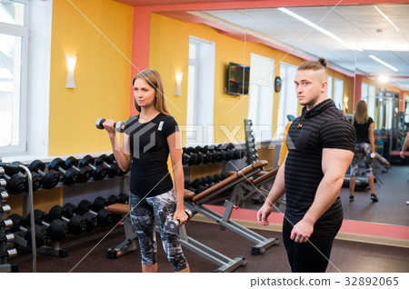 Woman with her personal fitness trainer in the gym 32892065