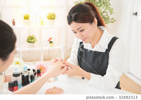 women manicurist checking nail care 32892313