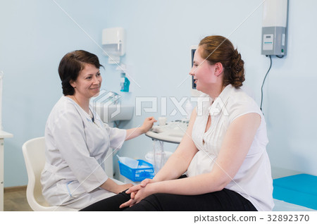 Gynecologist showing ultrasound photo to pregnant 32892370