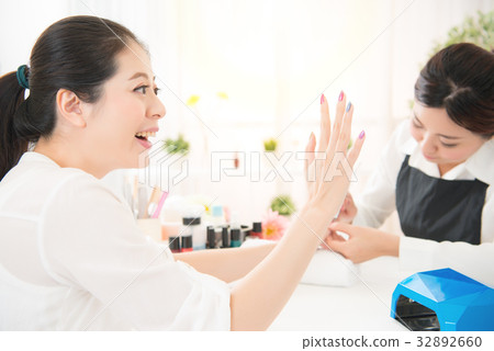 excited woman love her new done manicure 32892660