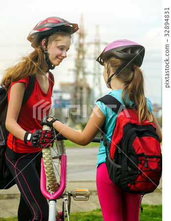 Girls children cycling pump up bicycle tire. 32894831
