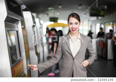 Business women using card at automatic machine 32895149