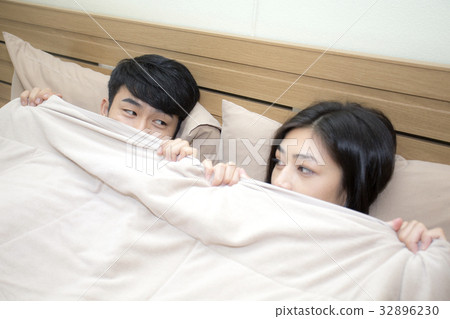 Asian man and woman lying in bed prepare to sleep 32896230