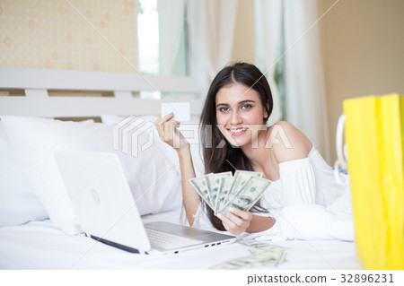 Young woman  holding money in bed 32896231