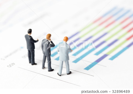 Miniature model of businessman standing on chart Miniature model of businessman standing on chart 32896489