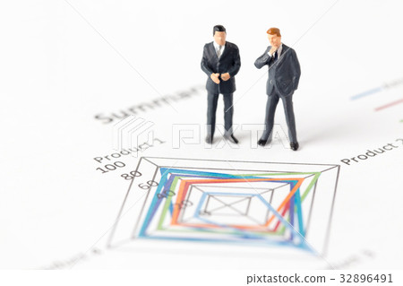 Miniature model of businessman standing on chart Miniature model of businessman standing on chart 32896491