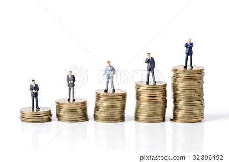 Miniature model of businessman standing on coin Miniature model of businessman standing on coin 32896492