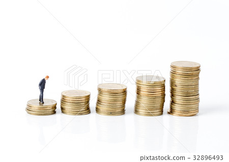 Miniature model of businessman walking on coin Miniature model of businessman walking on coin 32896493