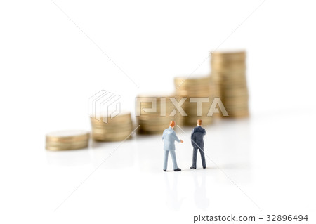 Miniature model of businessman walking on coin Miniature model of businessman walking on coin 32896494
