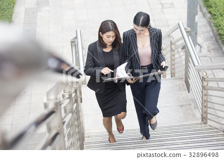 Business people talking for business plan while walking. Woman w Business people talking for business plan while walking. Woman w 32896498