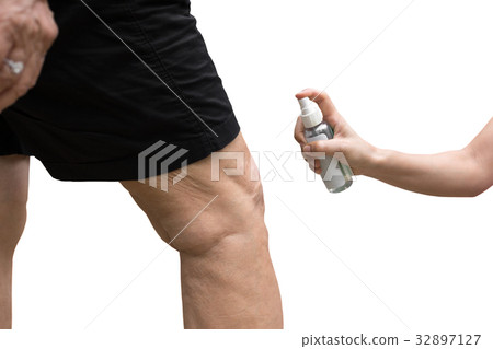 Daughter spraying insect repellent on mother legs  32897127