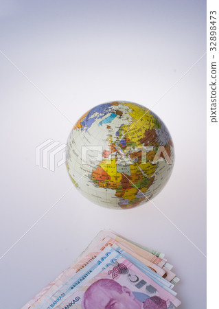 Turkish Lira banknotes by the side of a globe Turkish Lira banknotes by the side of a globe 32898473
