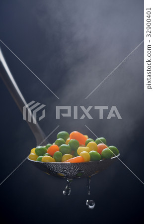 Boiled green peas, corn and carrot in a ladle with 32900401