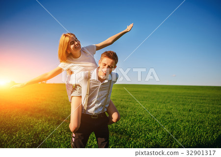 Smiling Man is holding on his back happy woman 32901317