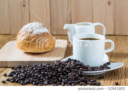 Coffee cup and sourdough roll on wooden table Coffee cup and sourdough roll on wooden table 32901805