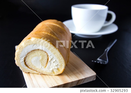 Swiss roll and coffee on wood background. 32905293