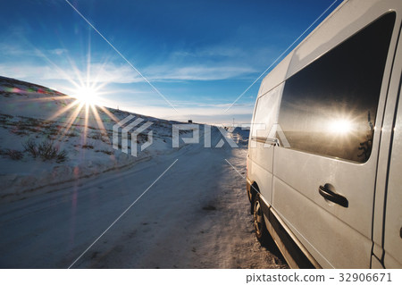 Car on side road in winter morning, with the sun  32906671