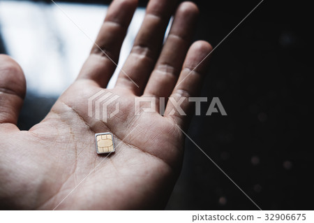 Microchip sim card on hand, selective focus Microchip sim card on hand, selective focus 32906675