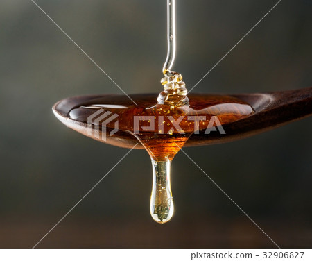 Honey pouring on spoon and dripping from spoon 32906827
