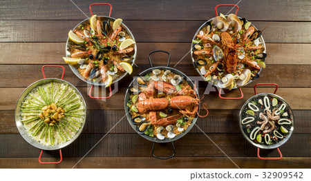 Assorted paella on wooden table, above view 32909542