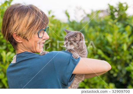 Playful domestic cat held and cuddled Playful domestic cat held and cuddled 32909700
