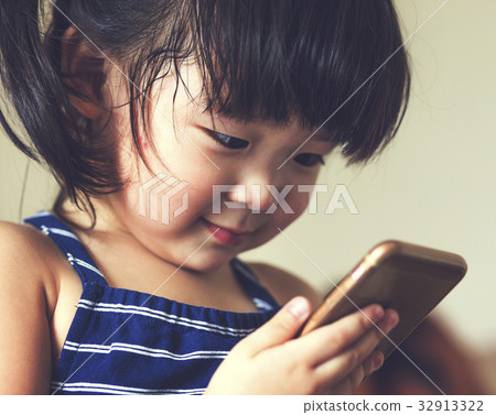 A little cute child playing cell phone device A little cute child playing cell phone device 32913322