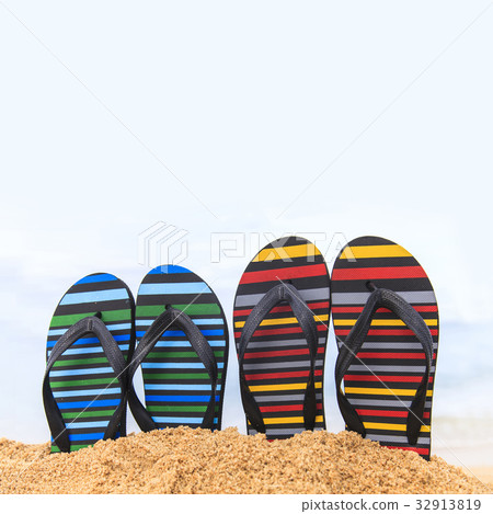 Flip flops on the sandy beach 32913819