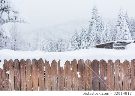 Snow covered wooden fence and snowy trees on Snow covered wooden fence and snowy trees on 32914912