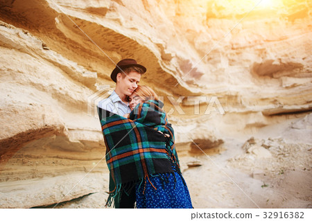 An attractive man hugs a beautiful woman.  32916382